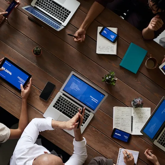 Bovenaanzicht van een vergadertafel met laptops